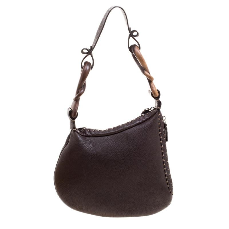 If you are looking for a unique bag, go for this Fendi Oyster hobo. It features a Selleria leather body with contrast stitch detailing and secured with a zipper closure. It comes fitted with a knotted shoulder strap and features a spacious suede