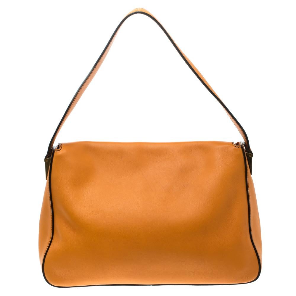 The Mama shoulder bag from Fendi is an all-time classic. Accented with the striking Forever lock in gold tone on the front flap, the piece carries an orange leather exterior. A spacious canvas interior and a leather strap complete the fabulous