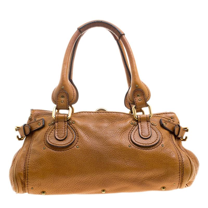 Chole’s Paddington satchel is glamorous indeed with a retro vibe. Gold tone hardware with a chunky lock on the front and the dangling chords with the keys grab all the attention. Crafted from brown leather the fabric interior is quite roomy and can