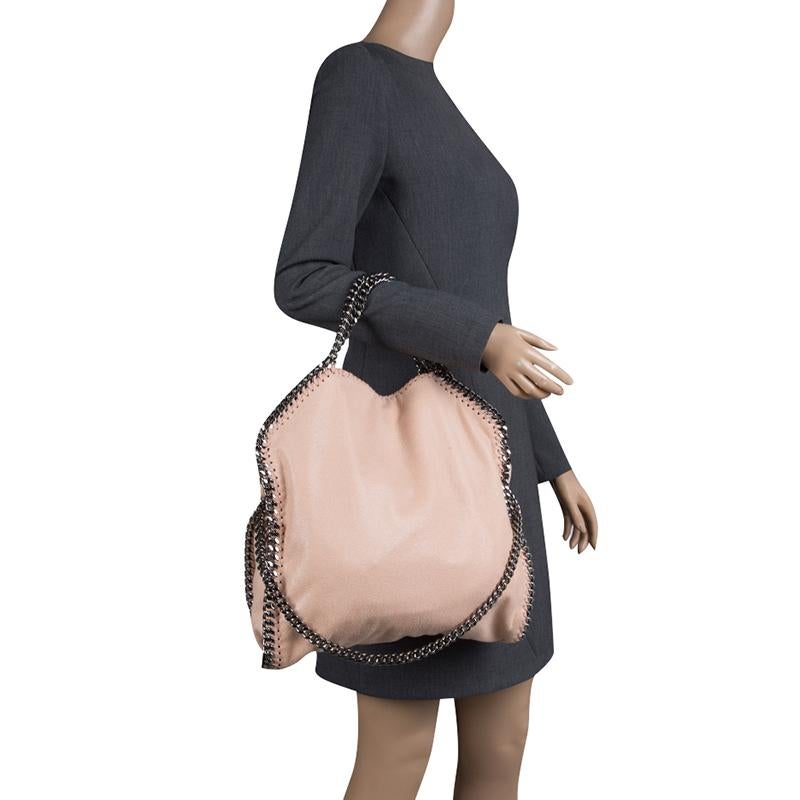 Stella McCartney is known for her chic designs and this Falabella tote perfectly embodies this trait. Crafted in Italy from pink faux leather with a fabric interior, this bag has a beautiful exterior and black tone chain details at its contours and