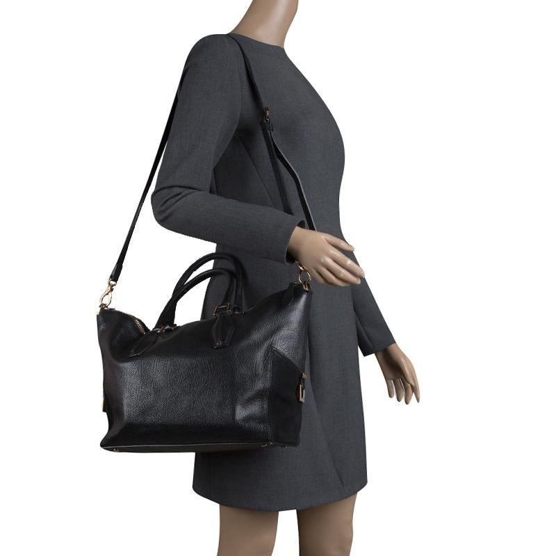 This black shopper tote from the Italian luxury fashion house, Tod's, is handy and the structure of the creation gives it a stylish edge. Crafted from leather the bag features dual handles, a detachable shoulder strap and protective metal feet at