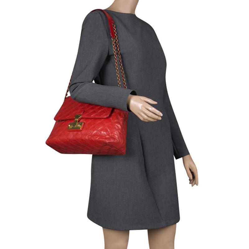 This elegant Marc Jacobs design is simply beautiful. The red quilted bag is crafted from leather and designed with gold-tone hardware and a flap which secures a spacious canvas interior. This bag is sure to make heads turn whenever you swing this
