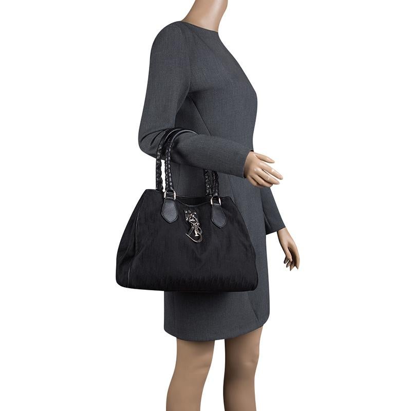 The Diorissimo bag from Dior is a piece that has never gone out of style. The canvas bag comes in a classy black shade with silver-tone hardware and Dior letter charms. It features two braided handles and a nylon interior with slip pockets and