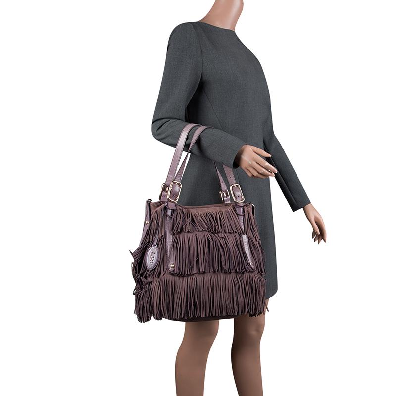 For a hobo-chic element in your ensembles, go for this Tod's G bag. It features a lilac leather body with panels of fringe all over. It comes with two flat top handles and secured with a zipper closure. The nylon-lined interior is spacious enough to