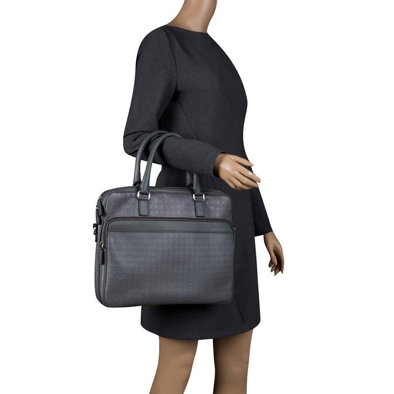 Wrapped in style and elegance, this laptop bag from Salvatore Ferragamo is a subtle blend of fashion and functionality. Its leather exterior is embossed with brand’s signature logo detailing and is supported by dual handles. The canvas lined