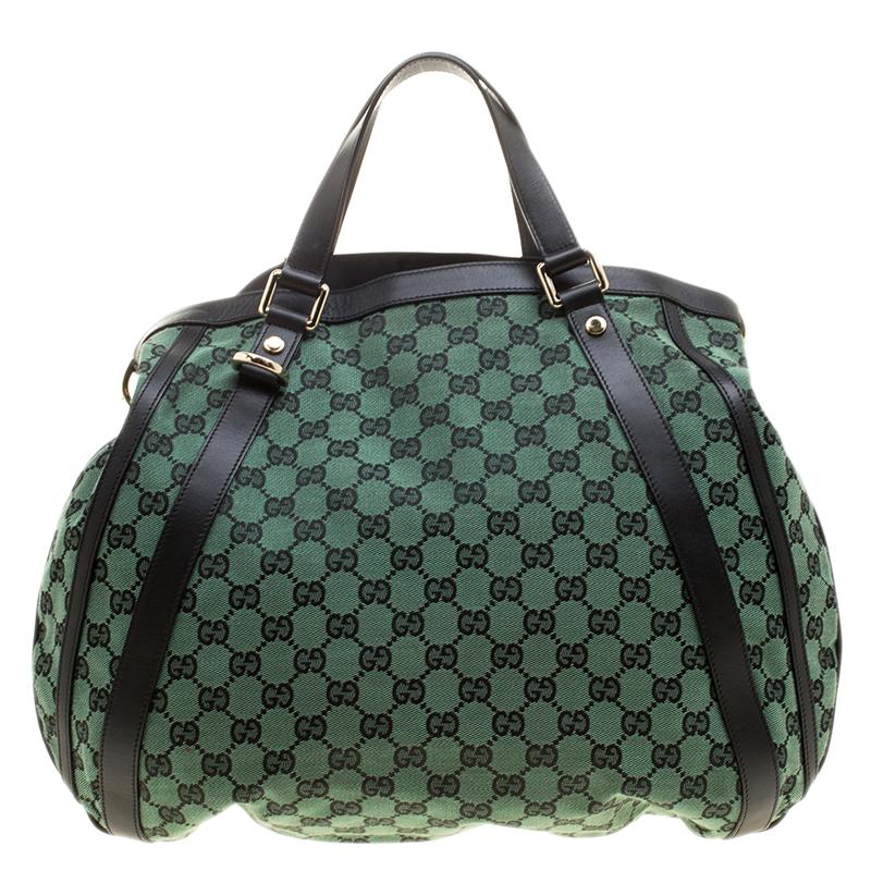 Gucci brings you this amazing Abbey bag that is smart and very modern. Made in Italy, this green bag is crafted from classic GG canvas and features black leather trims on the front, top handles along with detachable shoulder strap. The fabric lined