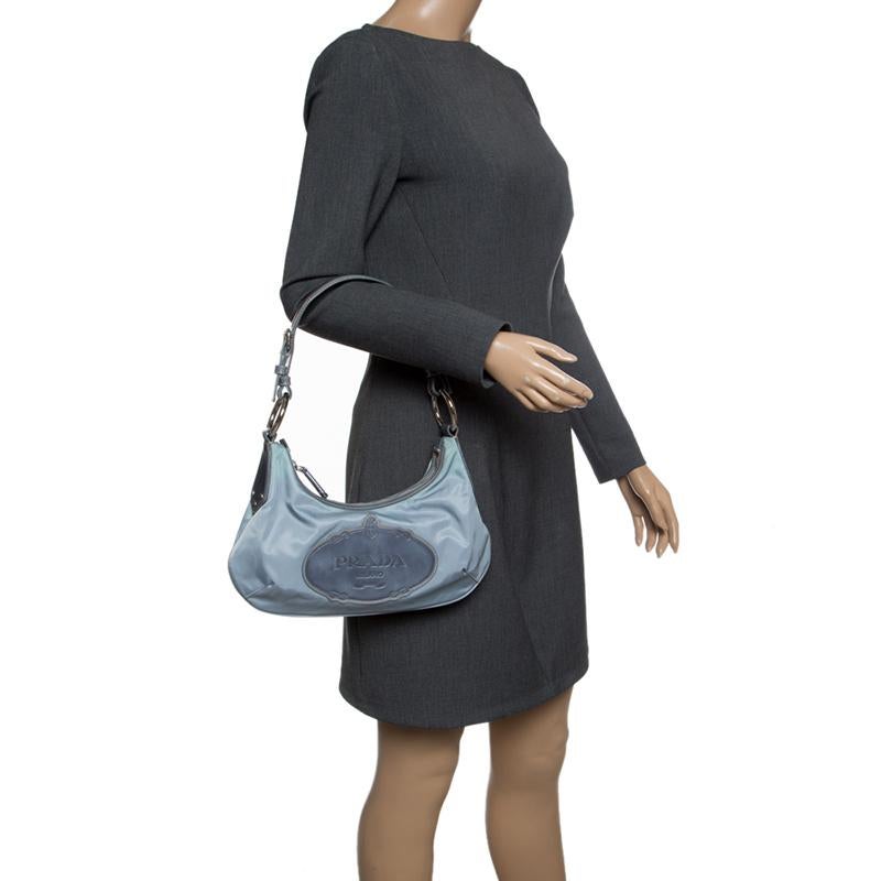 Poshness pairs with style for this distinguished piece. A light blue bag to match your dress for an evening out. This Prada creation is a high-quality product that is stylish and durable. Made in nylon, it has a single shoulder strap, the logo on