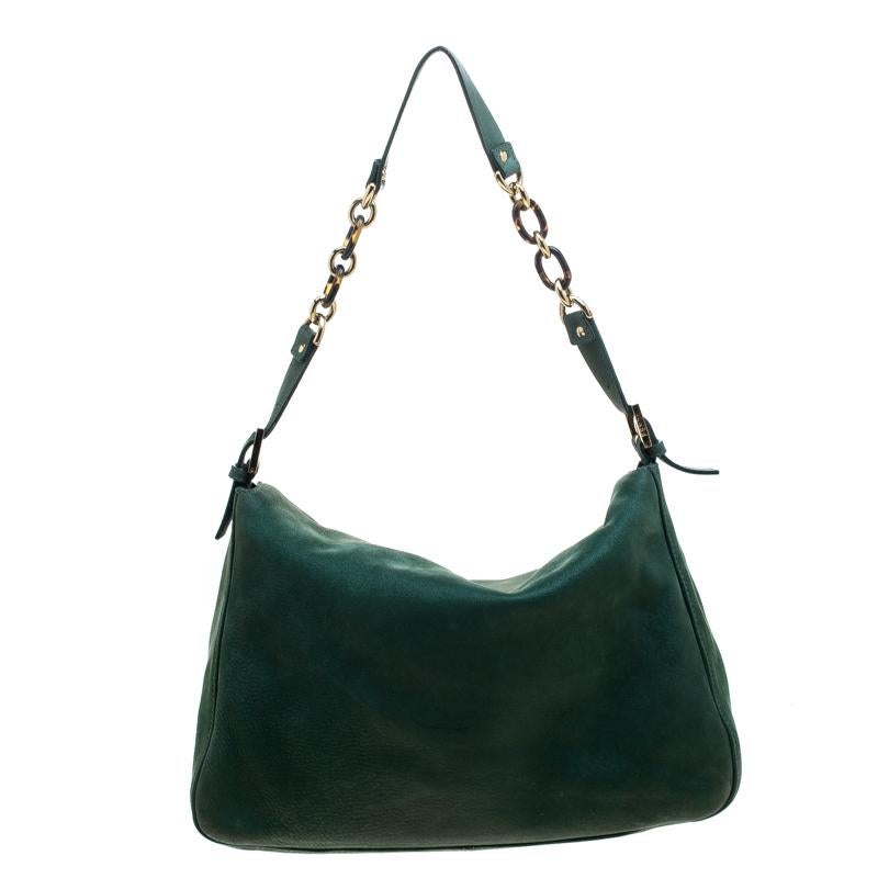 The Mama Forever shoulder bag from Fendi is an all-time classic. Accented with the striking Forever lock in gold tone on the front flap, the piece carries a green leather exterior. A spacious fabric interior and a leather strap complete the fabulous