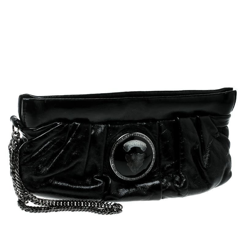 This Gucci clutch is built to suit your stylish ensembles. Crafted from patent leather, it has a black shade and a zipper which secures a leather interior. The clutch is complete with the signature Hysteria emblem on the front and a wrist