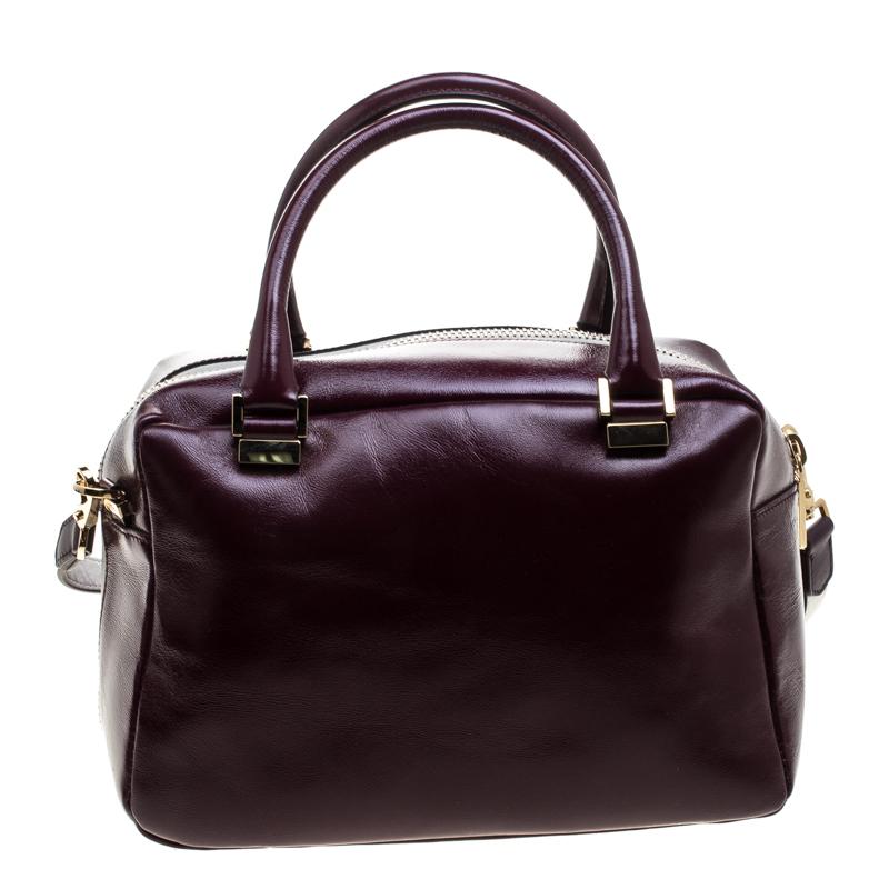 This Bowler bag from Tod's is simple in design but high on style. Crafted from glossy leather, the bag features double top handles, a shoulder strap and protective feet at the bottom. It has an exterior flap pocket and a top zipper reveals a fabric
