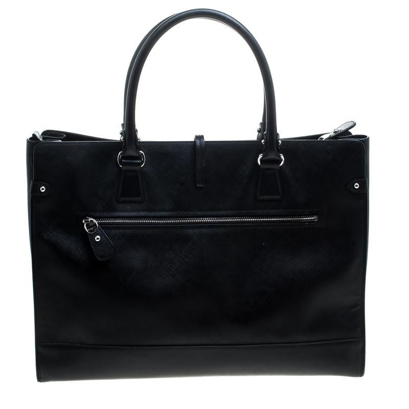 Crafted from leather, this black Salvatore Ferragamo tote comes with a spacious fabric interior. The bag is equipped with two handles and protective metal feet. Swing this beauty wherever you go to lend your outfit the appropriate measure of class
