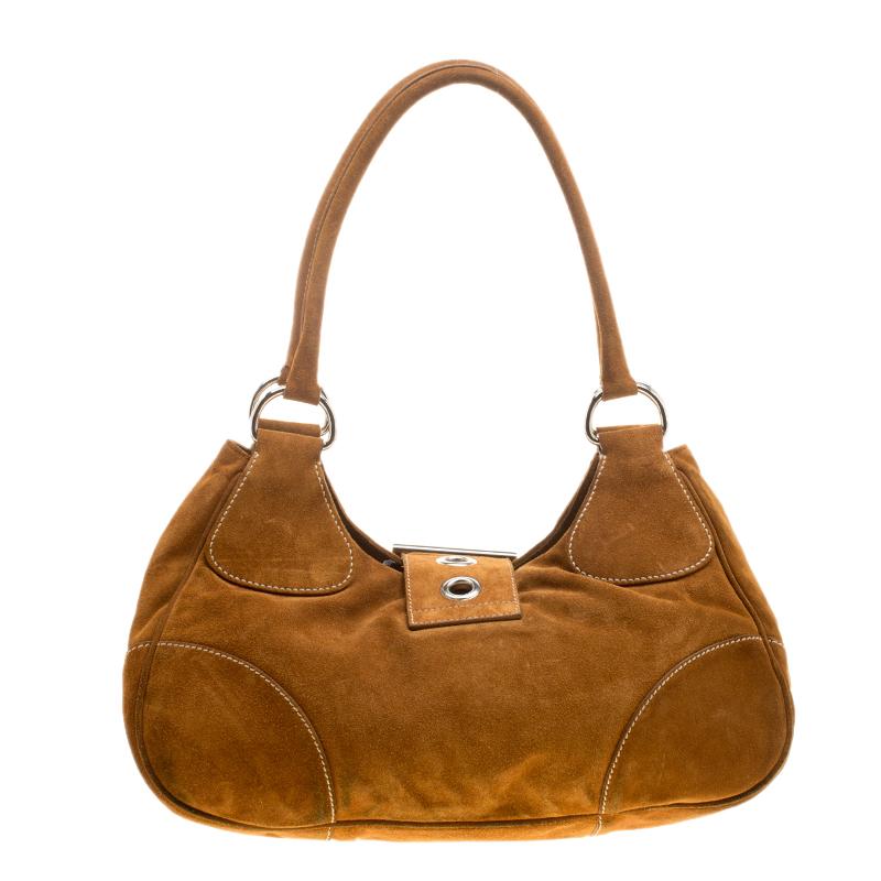 Create a stunning look with this versatile and trendy shoulder bag from Prada that has been crafted from dark camel suede. The nylon lining ensures ample space for your essentials while the two handles are for you to carry it. Raise your accessories