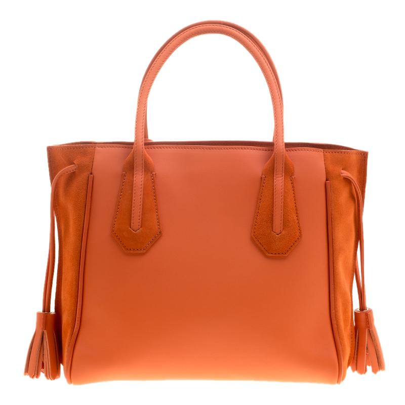Longchamp has exclusively made this classic tote to assist your style. The bag has a fabric interior, two handles and a tassel drawstrings on the sides. Excellent for all your outings is this sleek piece in orange. Fashioned with eye-catching