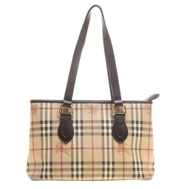 Simply gorgeous and built to last, this Burberry regent tote is a worthy investment. It has been crafted from PVC in their signature Haymarket check and equipped with dual handles and a spacious canvas lined interior. The bag is complete with gold
