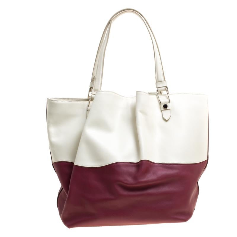 Flattering your look with a contemporary design is this Flower tote from Tod's. This bag in white and burgundy has been meticulously crafted from leather and equipped with a spacious satin interior that can easily hold all your essentials. Held up