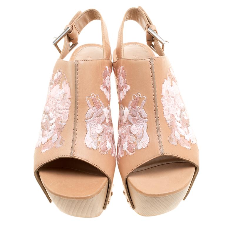 Add some elegant and feminine style with an unique touch to your day time wear collection with these Alexander McQueen wooden clogs. Constructed in peach leather along with chunky wooden platforms and curved heel, these shoes are completed with pink