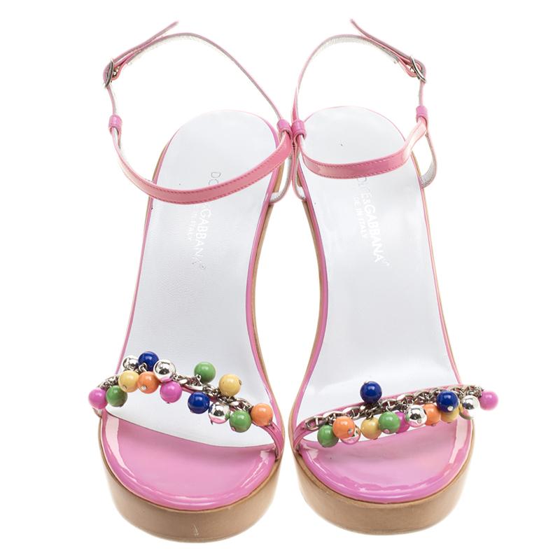 These Dolce and Gabbana sandals are perfect for those summer parties. Set on wedge sole, this pair features a pink patent leather body and detailed with multicolour bead embellishment on it. It features an open-toe style and looks best when styled