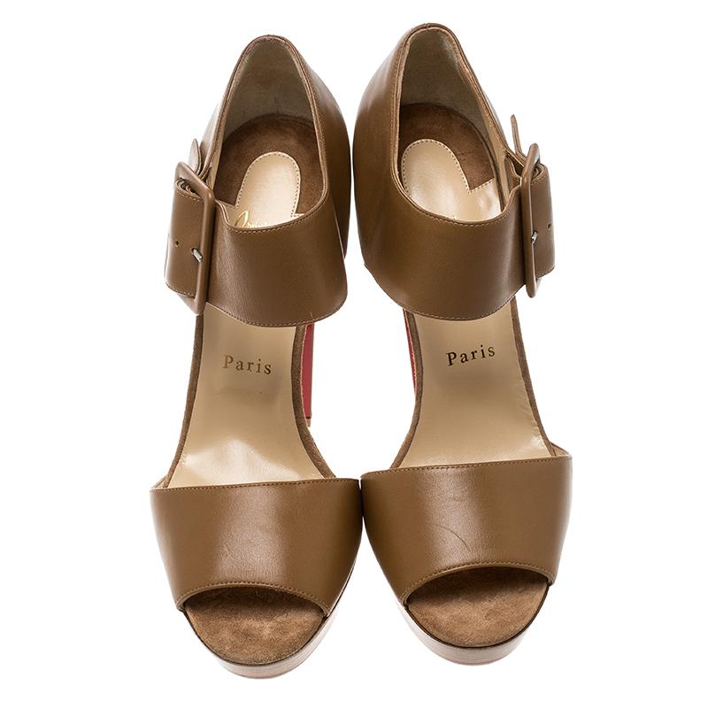 Feel fashion-forward when you step out in this sophisticated pair of Louboutins! Crafted from beige leather, the sandals have been designed with open toes, platforms, and large buckle ankle straps. The fabulous pair is complete with 14.5 cm heels