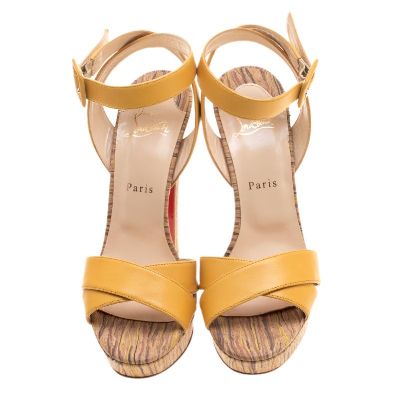 Christian Louboutin's sandals are that classic piece that you would want to wear time and again. Set on a corked platform sole and block heel, this pair comes with a yellow leather criss-cross ankle strap body and secured with an ankle tie-up with