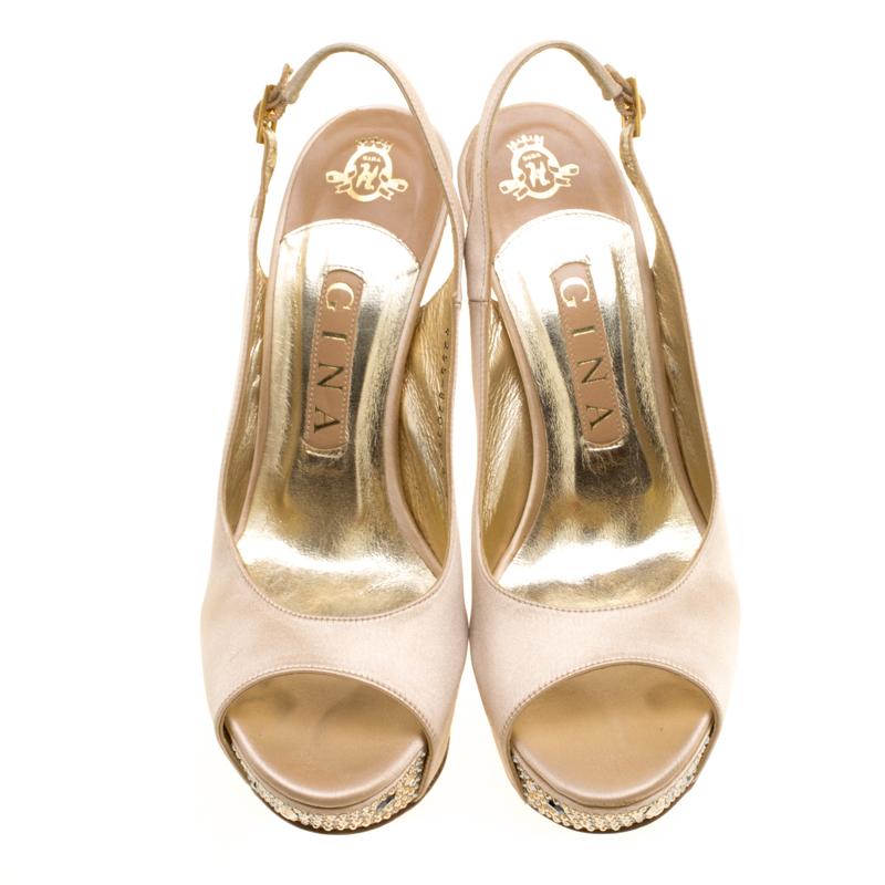 These sandals by Gina are utterly mesmerizing and filled with so much beauty, they make our hearts flutter. They carry a soul-soothing beige exterior with peep toes, slingbacks, and crystals decorated on the platforms and on the 13.5 cm heels.