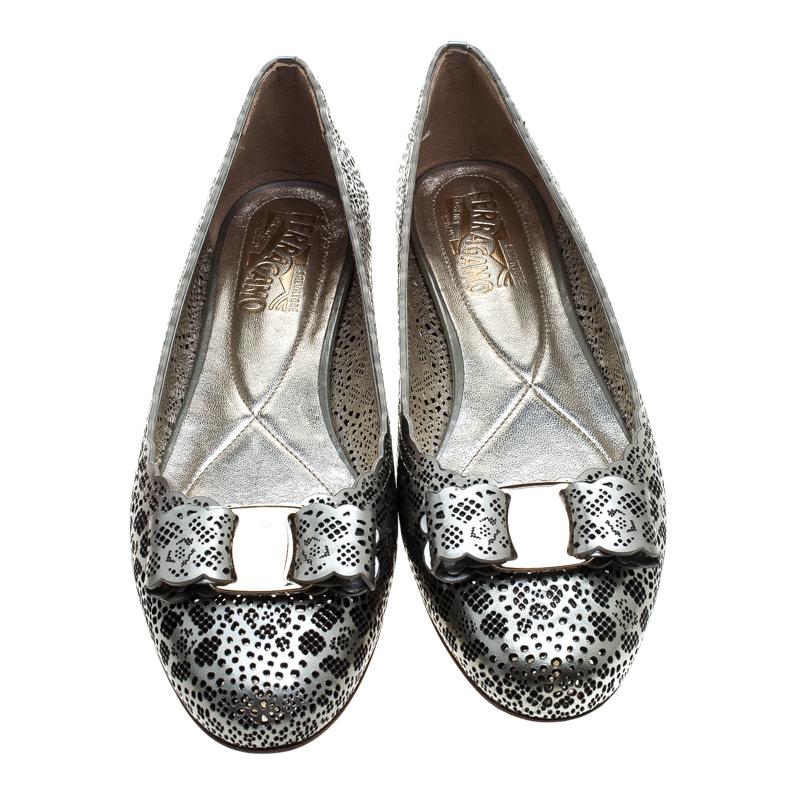 Fashion is the perfect blend of luxury with comfort, and this pair of pumps from the house of Ferragamo exudes just that. Crafted from metallic grey leather and styled with a scalloped topline, laser cuts all over, and their signature bows on the