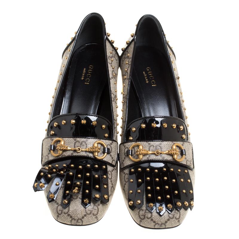 Super-comfortable and loaded with style, this pair of loafer pumps by Gucci will effortlessly complement your casuals or workwear. They've been crafted from GG Supreme canvas and styled with patent leather, studs, fringes and Horsebit details on the