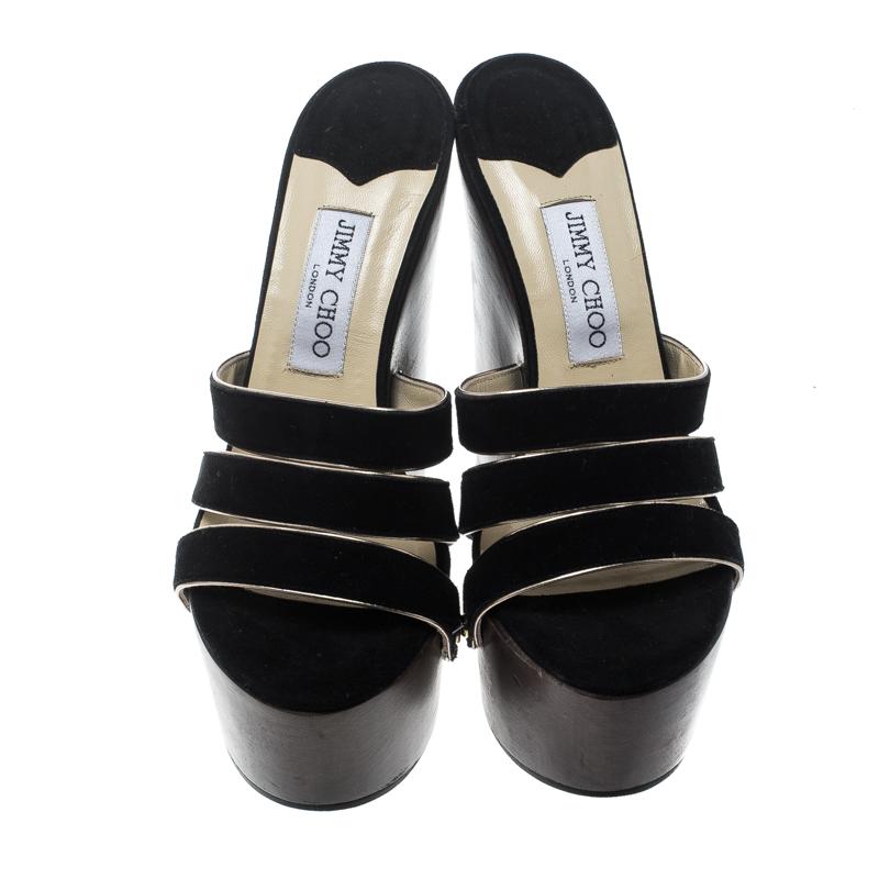 These Jimmy Choo sandals are perfect for fashionistas who love minimalist yet chic designs. Made in Italy, this pair has a brown suede exterior featuring three frontal straps secured by gold-tone studs perched on the smooth brown platforms and