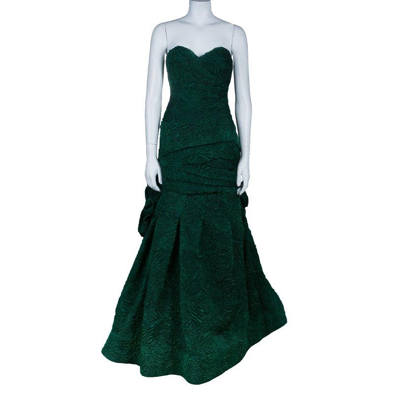 The elegance of a ball gown is redefined in this Minique Lhuillier design. It features a fitted bodice with a voluminous floor length gown. The strapless pattern with the sweetheart neckline and scoop back looks stunning. The tufted-skirt detailing