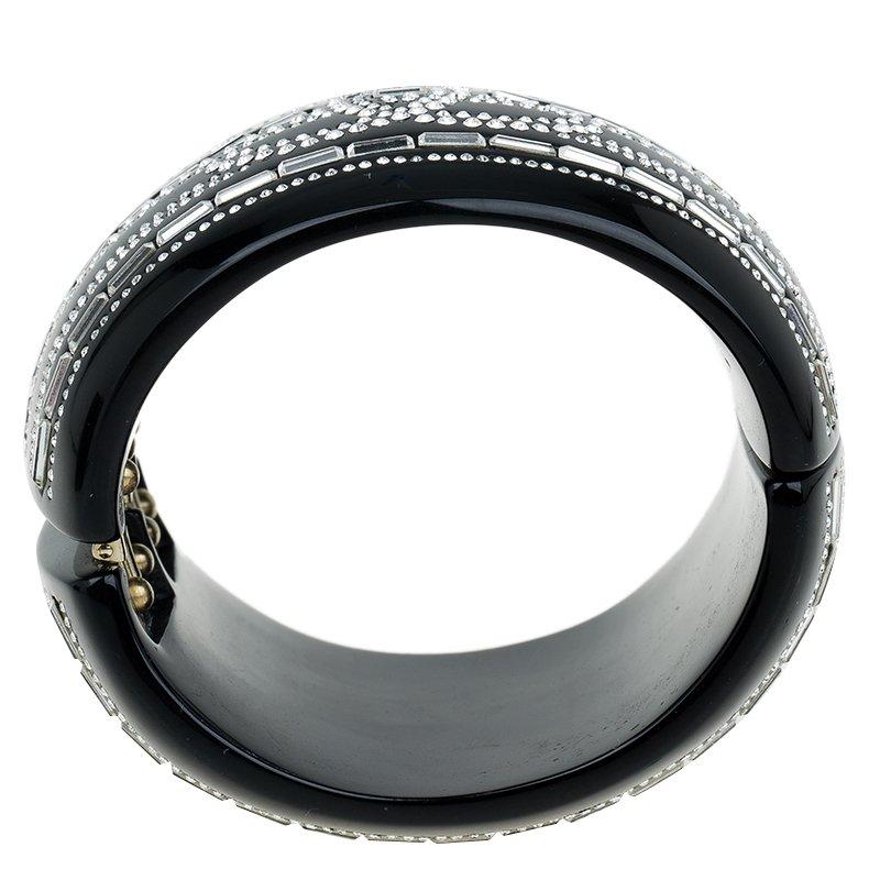Characteristic of immaculate finesse, the Chanel CC signature logo styled bracelet, is crafted to attribute elegance to your wrist and glamour to your attire. The black resin bangle is high on bling which is embellished with rectangular and smaller