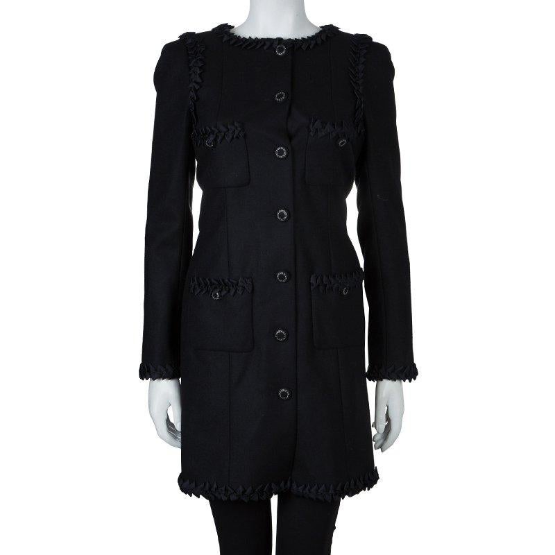 Chanel showcases the finest fabrics to design the classic-meets-contemporary fashion essential. This black overcoat is blend of wool and cashmere. The fitted structured coat has button detailing on the patched pockets and front full length placket