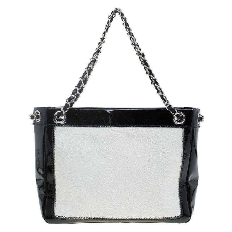 This Chanel’s black/white pony hair patent leather Runway tote features a patent leather pouch on the front carrying the signature 