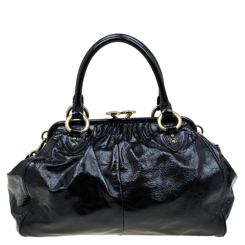 This Stam satchel bag from Marc Jacobs perfectly illustrates a classy lavish choice. Crafted from patent leather, this black Stam satchel bag is accentuated with a rich glossy demeanour and complimenting gold-tone hardware. Hold it by the double top