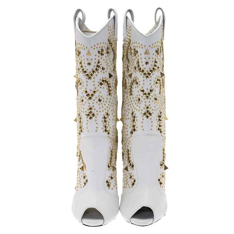 These boots resemble the cowboy boots of the Wild West, except that they are made out of fashionable white leather. The patterned studs, peep toe feature and stiletto heel add to the glamour of the boots. Pull-on tabs enable ease of wearing the