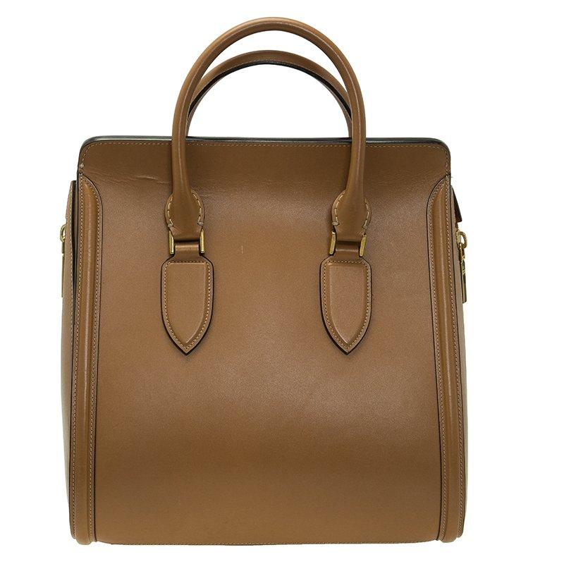 This classy bag from the house of Alexander McQueen is lovely! Crafted in elegant brown leather, this Heroine bag displays a structured silhouette. It is built on an expandable body and is held with two lateral vertical zips. The Heroine features