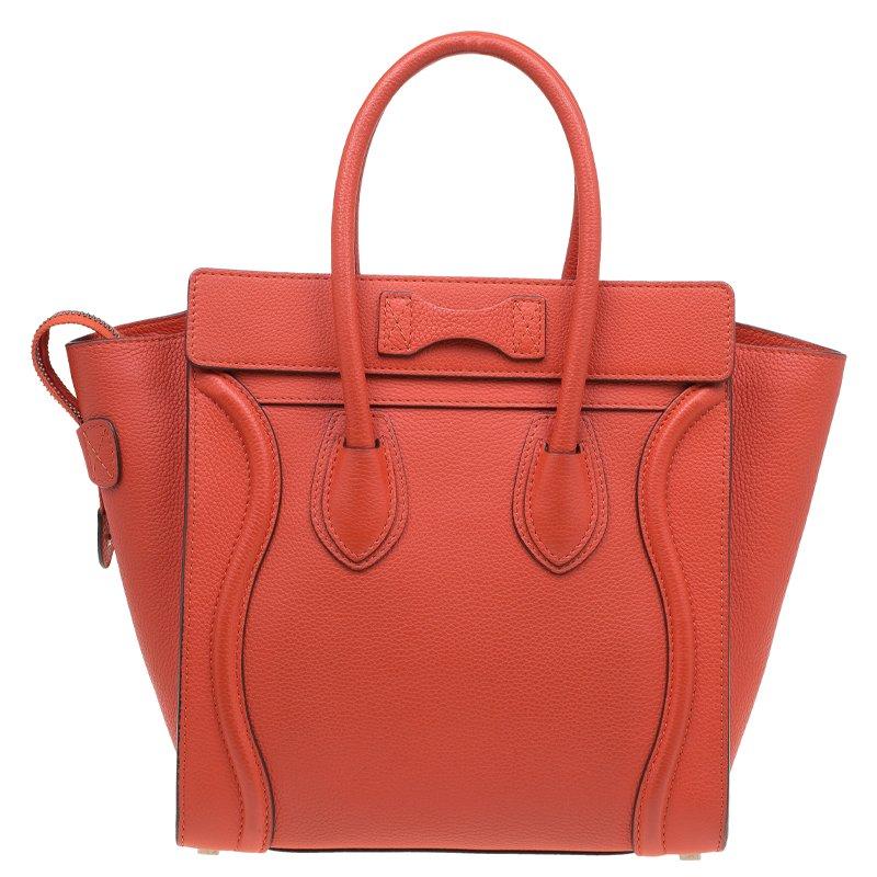 Travel in style with this micro luggage tote from the house of Celine. Designed in the signature structured shape, this orange tote comes with dual rolled top handles, wings on either side, and a zippered outer pocket. Finished with stitch detailing