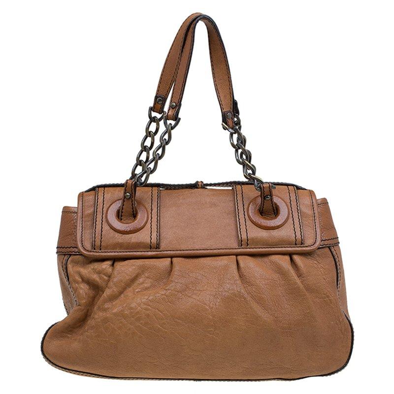This Fendi B tote bag will add contemporary vibe to casual separates. It is made from brown leather and is accented with large buckles with logo prongs, chain insets and gold-tone hardware. The interior is lined in black fabric and includes one