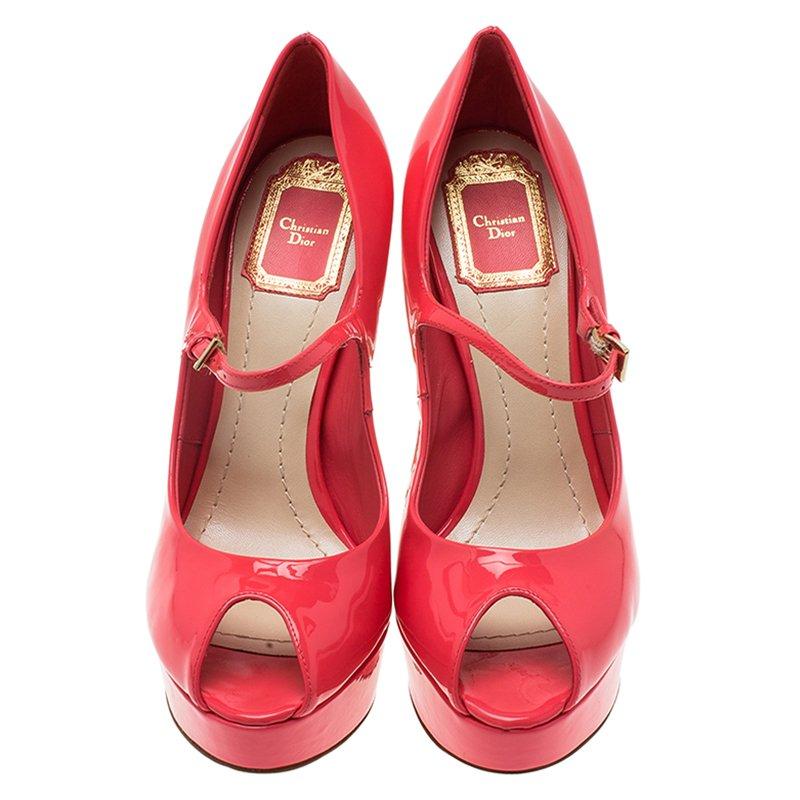 These classy ‘Miss Dior’ platform pumps by Christian Dior are made from pink shiny patent leather and are shaped with a flirty peep toe. It is secured with a buckled ankle strap that hits at the most flattering part of the foot. This pair is lifted