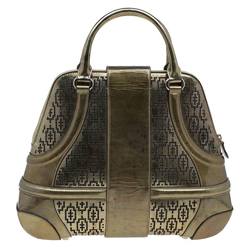 This Alexander McQueen Novak satchel is made of perforated patent leather in gorgeous gold colour. The fabric lining of the spacious compartment has a zippered pocket. The bag is secured with a zip as well as a turn lock on the central flap. Twin