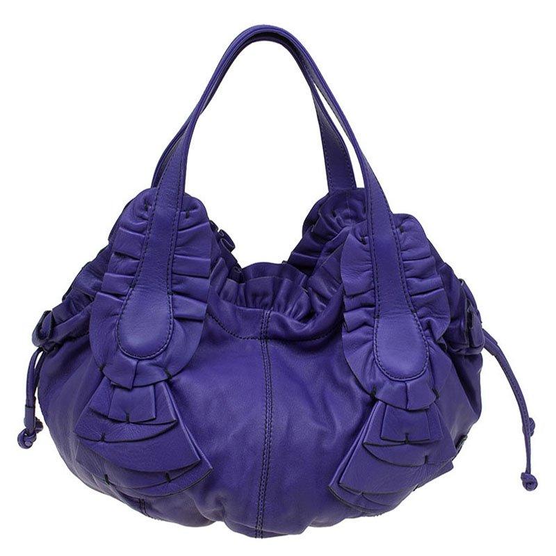 Valentino's hobo is made from supple purple leather with ruffle detailing. Showcase the style by carrying yours by the two flat top handles. The drawstring closure is enclosed and secured by a magnetic snap closure. The satin lined interior comes