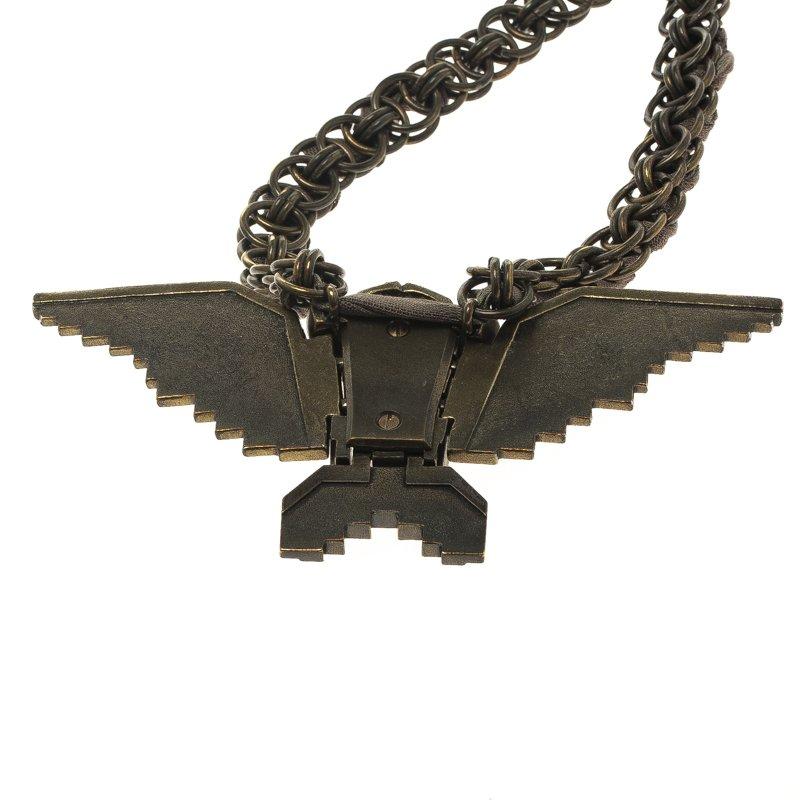 A statement neck piece from Lavin! Intricately designed this bold necklace has an eagle sculpted out of a metal base and studded with muted brown and orange crystals and studs. The stunning center piece hangs from a metal and fabric interlaced