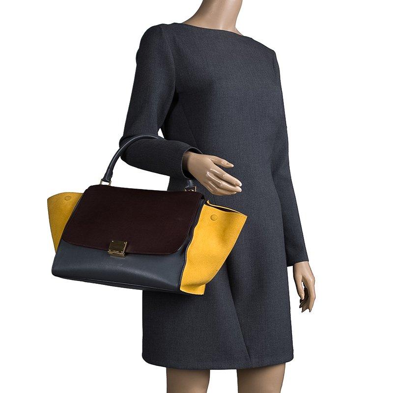 Featuring a chic, yet luxurious style, this Celine bag is distinctive. Crafted from leather and suede, this tote features signature flappy wings, gold-tone hardware and a zip pocket at the rear. The front flap of the tri-colored tote opens to a