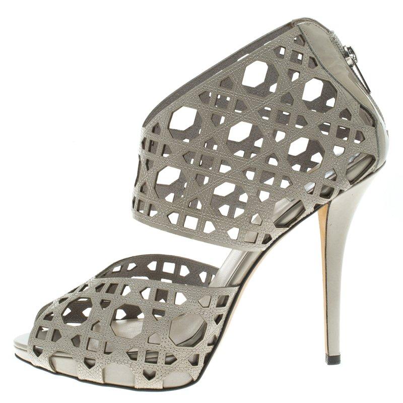 Let your feet do the talking in these Miss Dior Caged Sandals. Designed with exquisitely detailed cutouts on the grey leather exterior, this pair of Dior sandals exude luxury and style. They feature a peep-toe, and a closed back with a zip fastener
