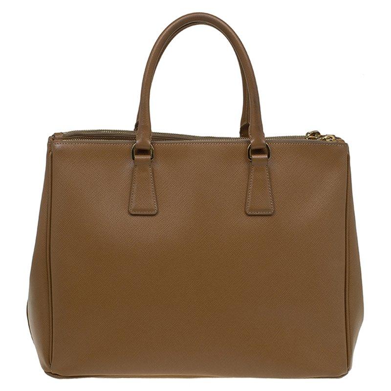 Crafted from a luxurious saffiano leather in a versatile brown hue, this bag from the house of Prada is a must-have for the anyone with an eye for class and style. Ideally compartmentalised to house all your essentials, this spacious bag comes with