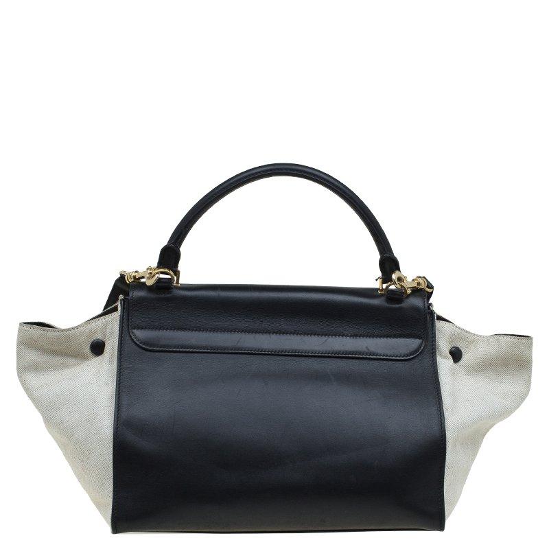 Made in Italy, this stylish Celine handbag is crafted in black and beige leather. It has gold-tone hardware, a top handle and a detachable shoulder strap for an easy carrying experience. The zip top closure opens to a leather lined interior and can