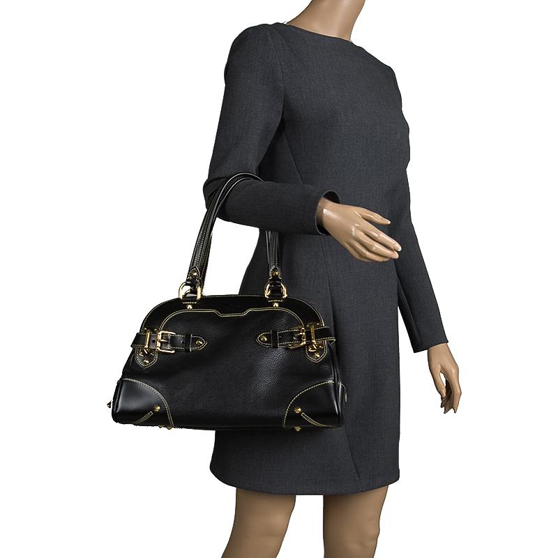 This Suhali Le Radieux bag from Louis Vuitton is gorgeous. The black beauty is crafted from leather and flaunts a unique and distinctive style. It features beautiful gold-tone pyramid studs, buckles, rings and the lock accent all of which shine to