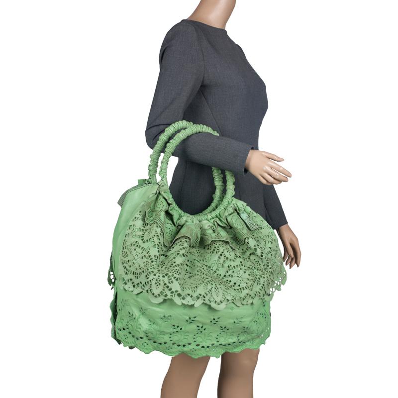 This intricately designed Laceland hobo is from Valentino. Crafted from light green leather the bag features a laser cut pattern all over and dual top handles. The neatly cut design gives an actual effect of lace. It comes with a satin lined