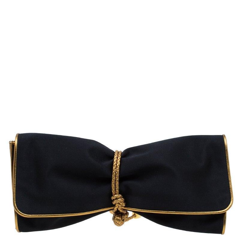 Adorn your evening outfit by carrying this gorgeous and captivating Malika Clutch from Gucci. Crafted from satin, it features an attractive gold borderline. It is accentuated with a fold-over flap, a braided knot and tasseled wraparound strap to