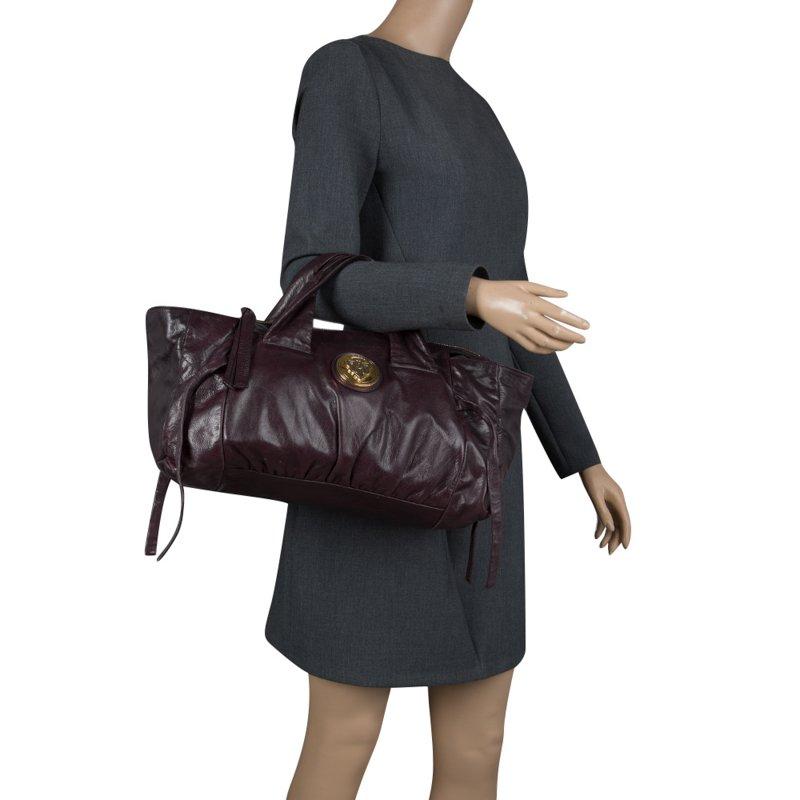 Flattering in a contemporary design is this Hysteria satchel from Gucci. The bag has been meticulously crafted from purple leather and is accented with Gucci’s iconic gold tone crest. The bag features dual top handles and a nylon lined interior that