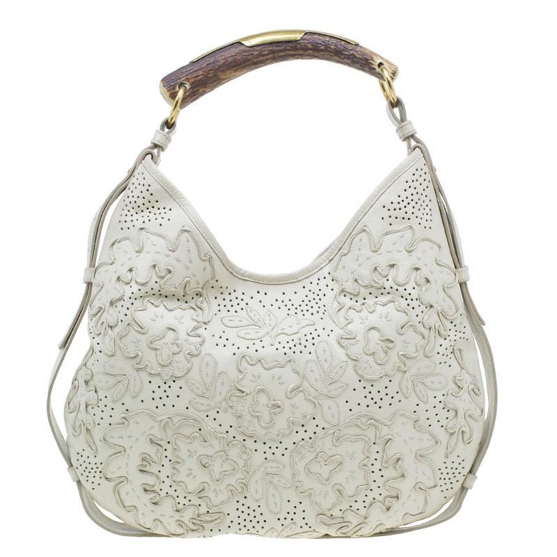 This unique and exotic hobo by Yves Saint Laurent, is a limited edition from the line of Mombasa Horn bags. Crafted in cream leather, it features a faux antelope horn handle with gold-tone accents. It displays beautiful leather detailing stitched on