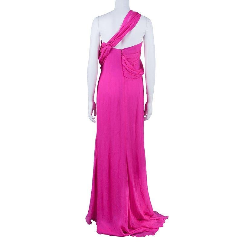This fairy tale draped gown in a hot pink shade from Oscar de la Renta is a breathtaking one! This one-shoulder dress features a pleated shoulder strap falling at the back creating a unique style. The pleated bust drape highlight and a side fall add